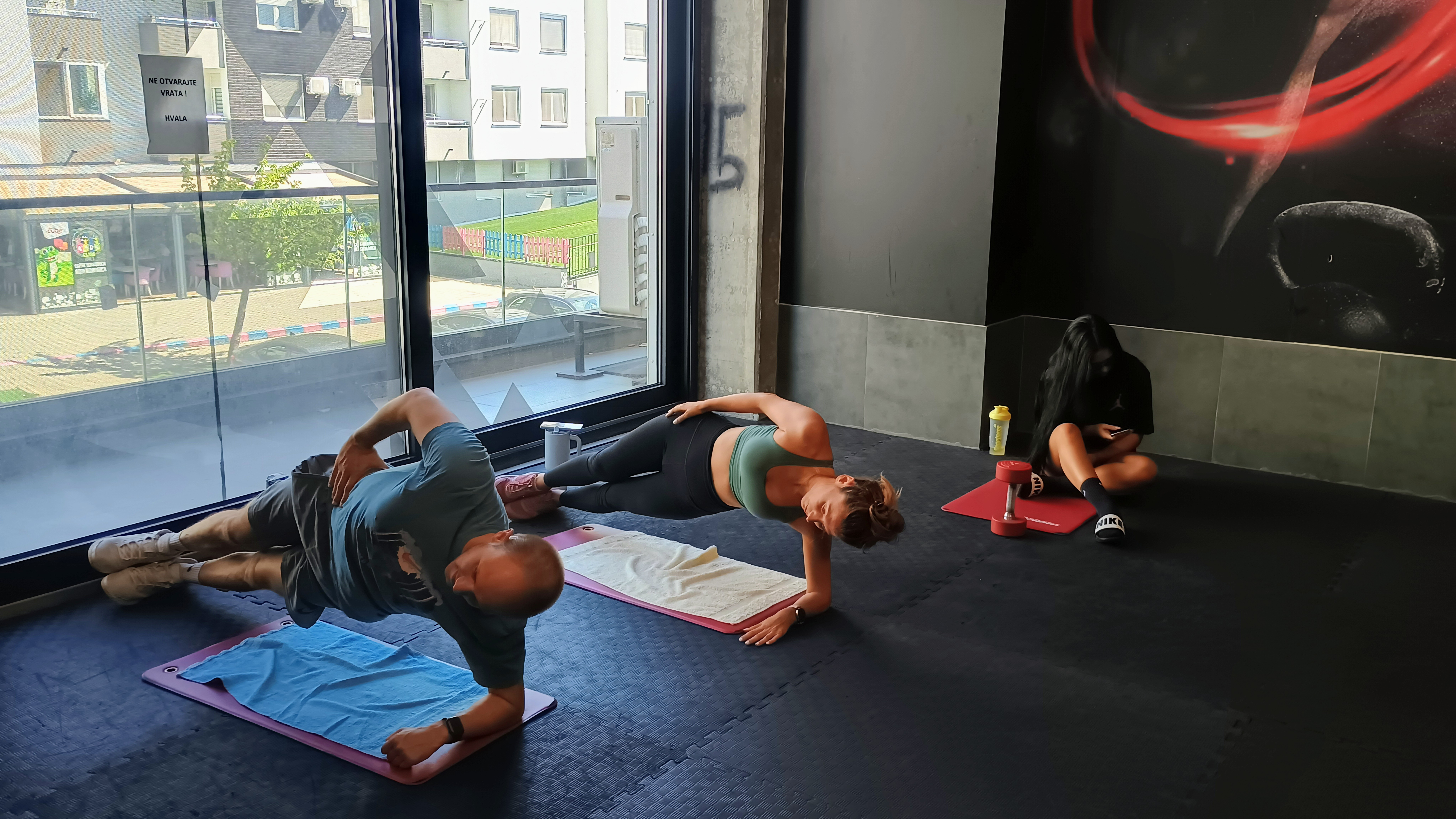 Dve osobe zajedno izvode vežbe tokom polupersonalnog treninga